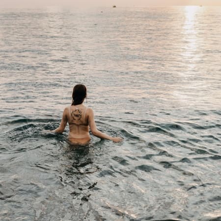 femme immergée dans l'eau jusqu'au bassin, illustrant de façon symbolique la baisse de l'inflammation et des douleurs pelviennes